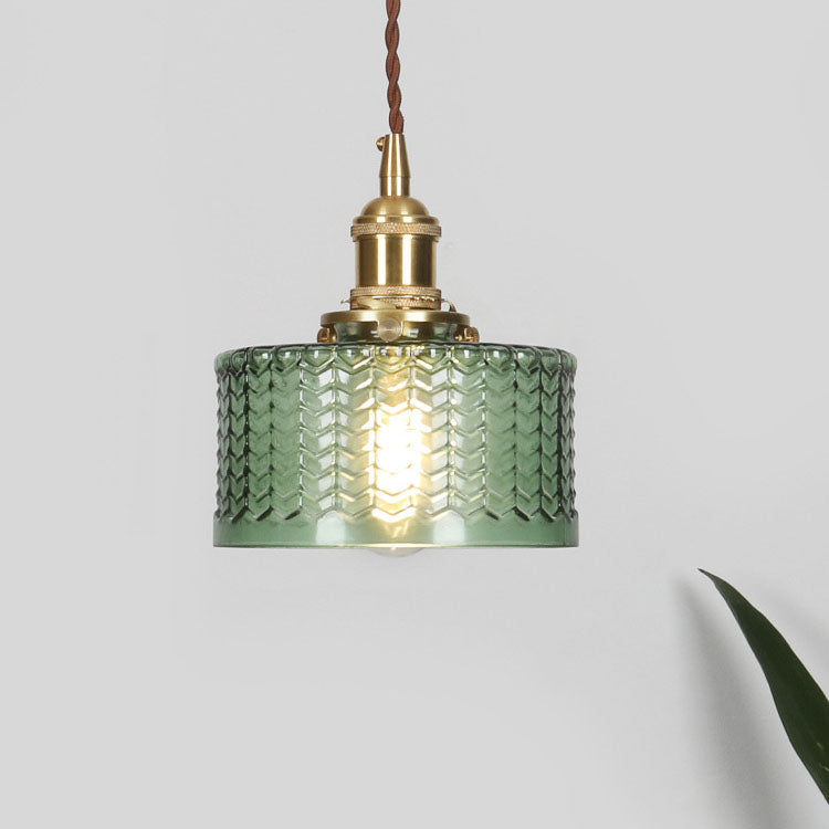 Round pendant light with brass finish and patterned glass shade