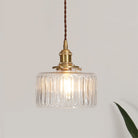 Round pendant light with brass finish and patterned glass shade