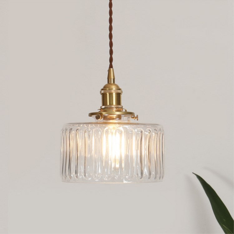 Round pendant light with brass finish and patterned glass shade