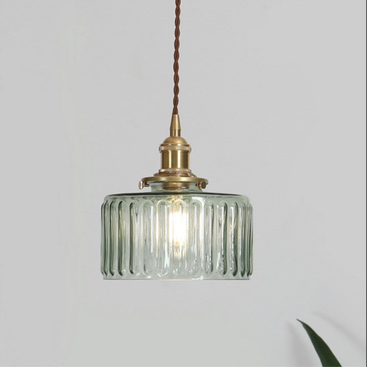 Round pendant light with brass finish and patterned glass shade