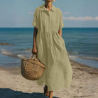 Women's collared button maxi dress with short sleeves and gathered waist at the beach