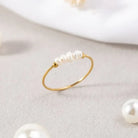 Gold-tone pearl ring with a row of white pearls