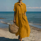 Women's collared button maxi dress with short sleeves and gathered waist at the beach