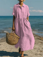 Women's collared button maxi dress with short sleeves and gathered waist at the beach