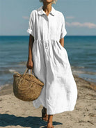 Women's collared button maxi dress with short sleeves and gathered waist at the beach