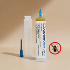 Cockroach gel bait syringe with blue nozzle applying yellow gel indoors