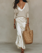 Women's satin midi dress layered with a ribbed knit sweater