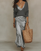 Women's satin midi dress layered with a ribbed knit sweater