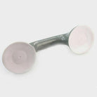 White and gray no-drill bathroom grab bar mounted on a tiled shower wall