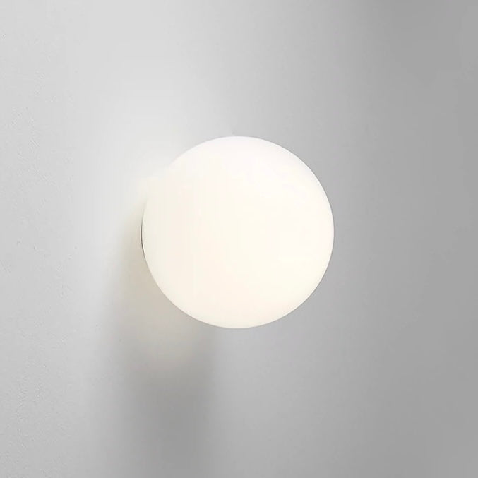 Modern frosted glass globe LED wall sconce mounted on a wall