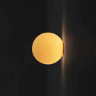 Modern frosted glass globe LED wall sconce mounted on a wall