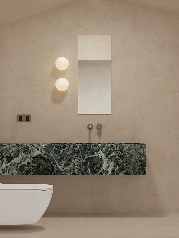 Modern frosted glass globe LED wall sconce mounted on a wall