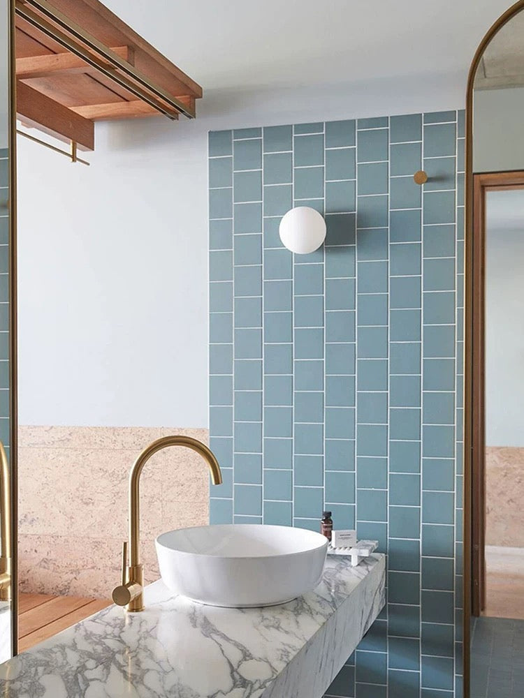 Modern frosted glass globe LED wall sconce mounted on a wall
