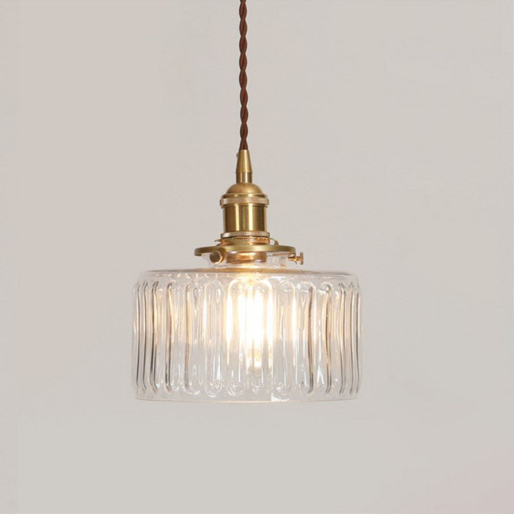 Round pendant light with brass finish and patterned glass shade
