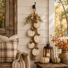 Rustic white pumpkin wall hanging with rope, greenery and plaid bow