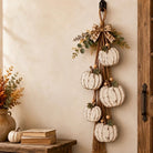 Rustic white pumpkin wall hanging with rope, greenery and plaid bow