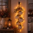 Rustic white pumpkin wall hanging with rope, greenery and plaid bow
