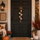 Rustic white pumpkin wall hanging with rope, greenery and plaid bow