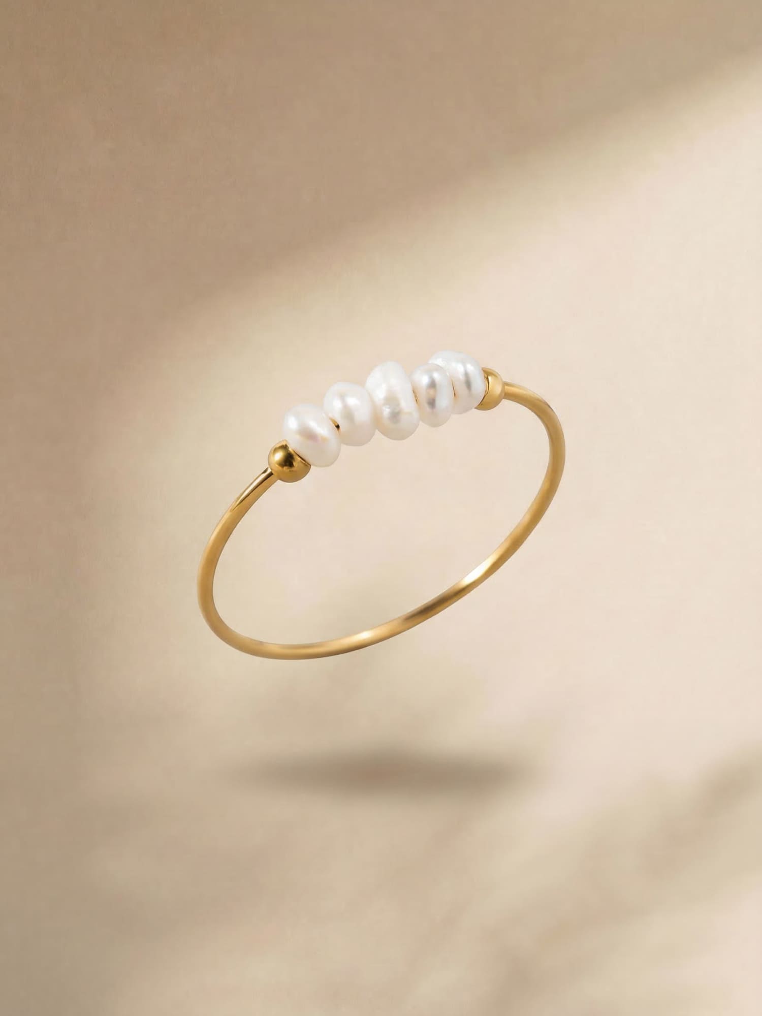 Gold-tone pearl ring with a row of white pearls