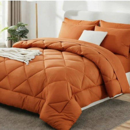 Quilted comforter with geometric diamond stitching on a bed