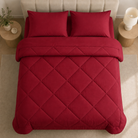 Quilted comforter with geometric diamond stitching on a bed